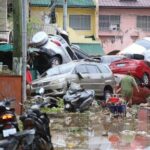typhoon-leaves-at-least-2-dead,-traps-people-on-roofs-and-submerges-cars
